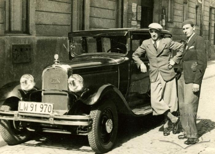 Two men near a passenger car on the street 2