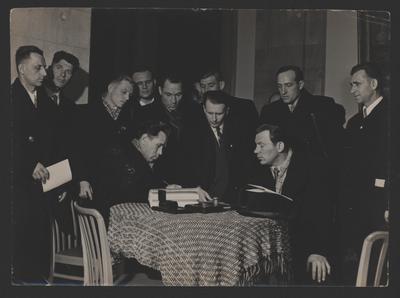Чоловіки біля столу, підписання паперів
