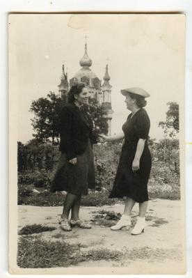 Two women standing with the Andriivska church in the background