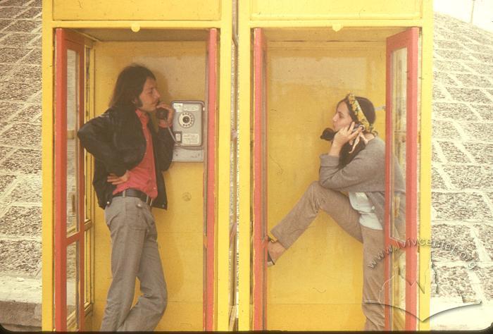 Young man and woman inside telephone booths 2