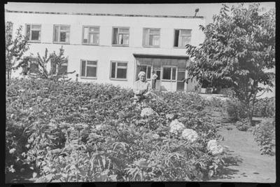 Працівниця прибирає територію
