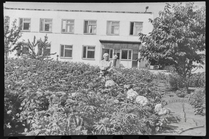 Працівниця прибирає територію 2